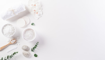 Cosmetic bottle containers, skin cream with flowers. Natural beauty and spa concept, Top view on white table background. - obrazy, fototapety, plakaty