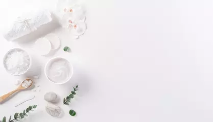 Rolgordijnen Cosmetic bottle containers, skin cream with flowers. Natural beauty and spa concept, Top view on white table background. © Siam