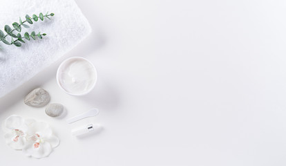 Cosmetic bottle containers, skin cream with flowers. Natural beauty and spa concept, Top view on white table background.