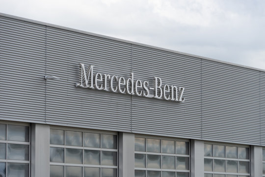 Munich, Bavaria / Germany - August 23, 2020: Mercedes-Benz logo hanging on a modern car dealer building. Mercedes-Benz is a global automobile brand and a division of the German DAX company Daimler AG