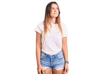 Obraz premium Beautiful caucasian woman wearing casual white tshirt smiling looking to the side and staring away thinking.