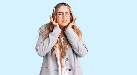 Young beautiful blonde woman wearing call center agent headset covering ears with fingers with...