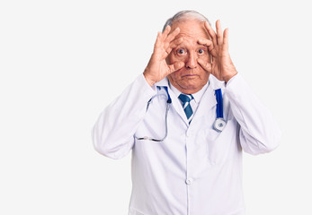 Senior handsome grey-haired man wearing doctor coat and stethoscope trying to open eyes with fingers, sleepy and tired for morning fatigue