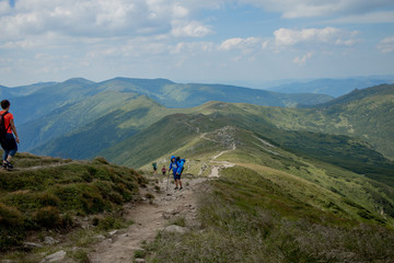 Fototapeta na wymiar Hiker on the top in Carpathians mountains. Travel sport lifestyle concept