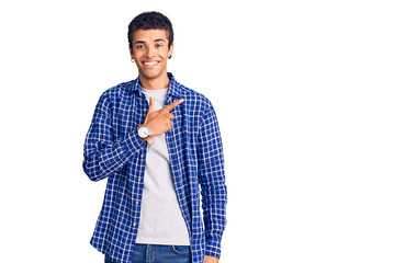 Young african amercian man wearing casual clothes cheerful with a smile on face pointing with hand and finger up to the side with happy and natural expression