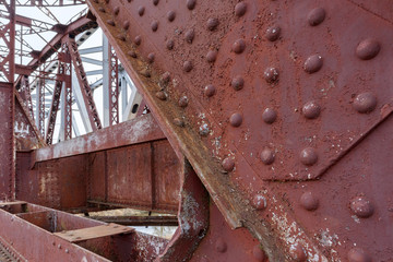 Some part of old steel construction of train bridge, construction details with metal girders, bolts...