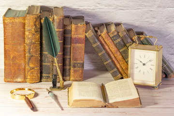 Antique watch along with antique books and vintage writing pen.