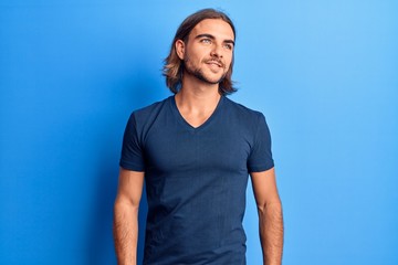 Young handsome man wearing casual clothes looking to side, relax profile pose with natural face and confident smile.