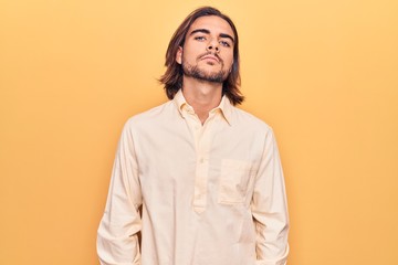 Fototapeta premium Young handsome man wearing business clothes relaxed with serious expression on face. simple and natural looking at the camera.