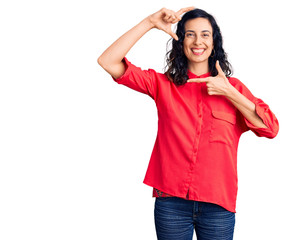 Fototapeta premium Young beautiful hispanic woman wearing casual clothes smiling making frame with hands and fingers with happy face. creativity and photography concept.