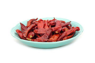 Dried red hot chili peppers on ceramic dish isolated on white background