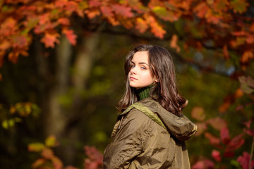 Teenager girl on autumn red maple leaves at fall outdoors. Portrait of a beautiful teen.