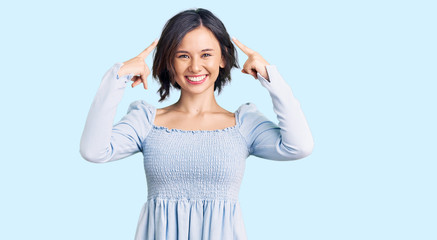 Fototapeta premium Young beautiful girl wearing casual clothes smiling pointing to head with both hands finger, great idea or thought, good memory