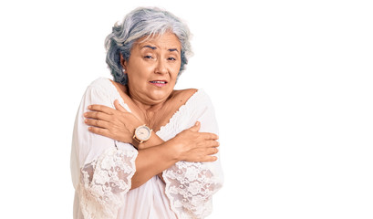 Senior woman with gray hair wearing bohemian style shaking and freezing for winter cold with sad and shock expression on face