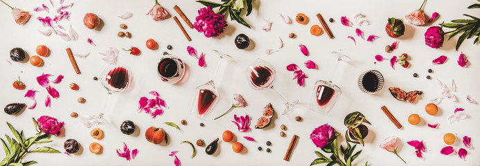 Red wine in glasses with flavours symbols. Flat-lay of wine glasses, fruit, flowers, spices and...