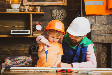Father is teaching his son to use the screwdriver and hammer. Work with tools construction. Child...