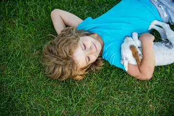 Child and white puppy outdoors in summer.