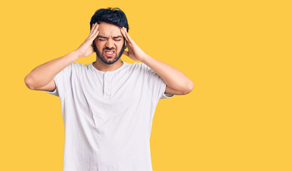 Young hispanic man wearing casual clothes suffering from headache desperate and stressed because pain and migraine. hands on head.