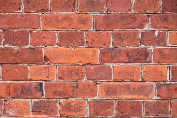 Background bricks wall. Texture with red bricks. Masonry with bricks of different sizes. Grounge abstract texture or background. Background from a brick wall of a building.