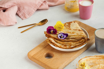 Delicious crepes on plates, coffee mugs. Concept of Breakfast, dessert, recipe, French cuisine, Maslenitsa.