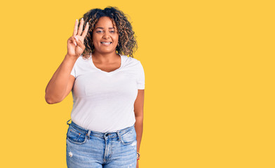 Young african american plus size woman wearing casual clothes showing and pointing up with fingers number three while smiling confident and happy.