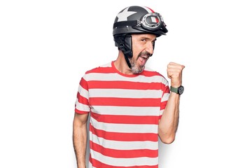 Middle age handsome motorcyclist man wearing moto helmet over isolated white background pointing thumb up to the side smiling happy with open mouth