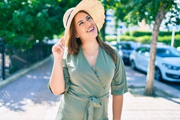 Young hispanic woman on vacation smiling happy walking at street of city