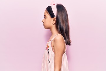 Beautiful child girl wearing casual clothes looking to side, relax profile pose with natural face...