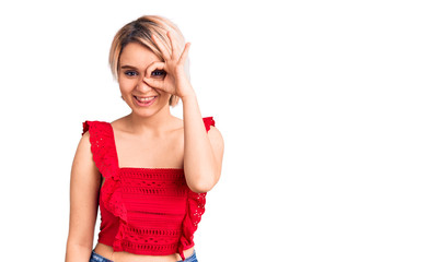 Young beautiful blonde woman wearing casual clothes doing ok gesture with hand smiling, eye looking through fingers with happy face.