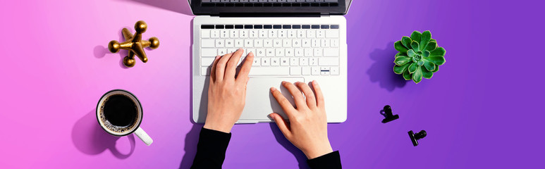Woman using a laptop computer with office supplies