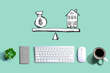 House and money on the scale with a computer keyboard and a mouse