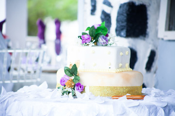 white and gold birthday cake with flowers