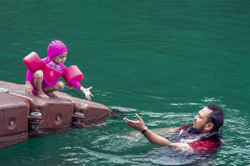 Asian family swimming at the Kenyir Lake, Malaysia.