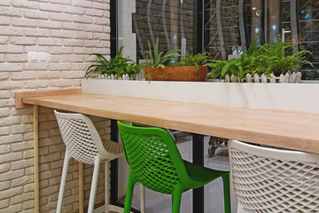 empty chairs table and green plants next to cafeteria window indoors