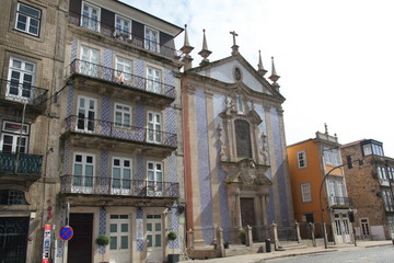 Obraz premium Blue azulejos church and yellow building near the Palacio da Bolsa, mercado Ferreira Borges and statue of Infante Dom Henrique in Porto downtown center, Portugal