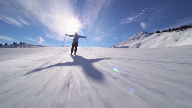 Professional skier skiing on slopes in the Swiss alps. Spreading hands and skiing of frame.
