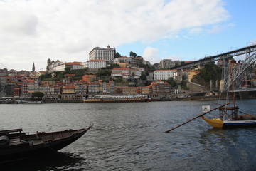 Dom Luis I bridge and traditional boats with wine barrels on Rio Douro river in Porto, Portugal