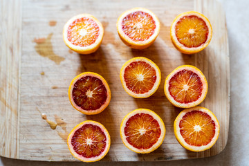 blood orange sliced halves on wooden chopping board