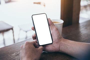 cell phone mockup image blank white screen.man hand holding texting using mobile on desk at coffee shop.background empty space for advertise.work people contact marketing business,technology