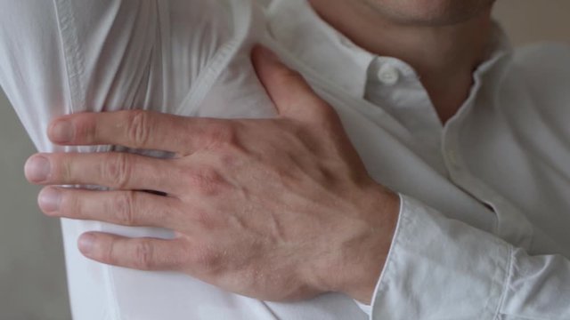 Adult Male Wearing White Shirt Lifting Up Right Arm To Reveal Sweat Patch. Slow Motion
