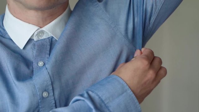 Male Wearing Blue Shirt Lifting Up Left Arm And Pinching Sweat Patch. Locked Off 