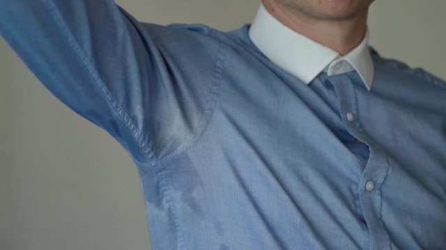 Adult Male Wearing Blue Shirt Lifting Up Right Arm To Reveal Sweat Patch. Slow Motion