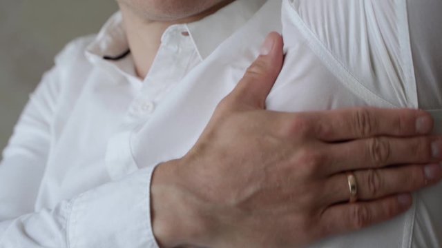 Male Wearing White Shirt Lifting Up Left Arm To Reveal Sweat Patch And Touching It. Slow Motion, Locked Off 