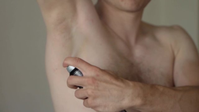 Spray On Antiperspirant Deodorant Being Applied To Male Right Armpit. Close Up