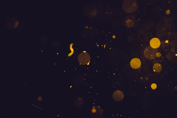 Naklejka premium Dark Abstract Gold bokeh sparkle on black