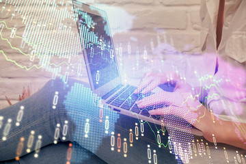 Multi exposure of woman hands typing on computer and forex chart hologram drawing. Stock market analysis concept.