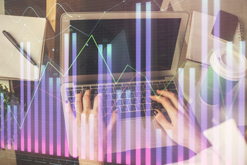 Double exposure of woman hands typing on computer and forex chart hologram drawing. Stock market invest concept.