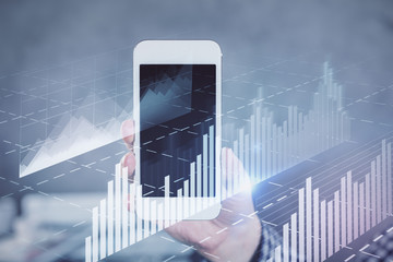 Double exposure of man's hands holding and using a digital device and forex graph drawing. Financial market concept.