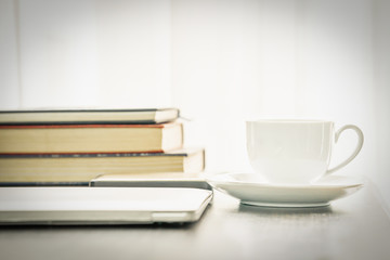 Coffee cup and laptop with book