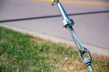 Power line guy strand tensioner vise support on anchor cable © Lost_in_the_Midwest